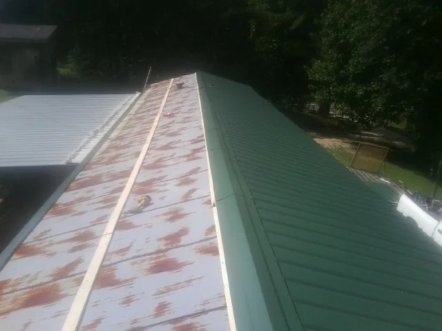 Old rusted panels beside newly installed green metal roofing — Wind Damage Roof Repair by Roofing Brothers in Beverly Hills